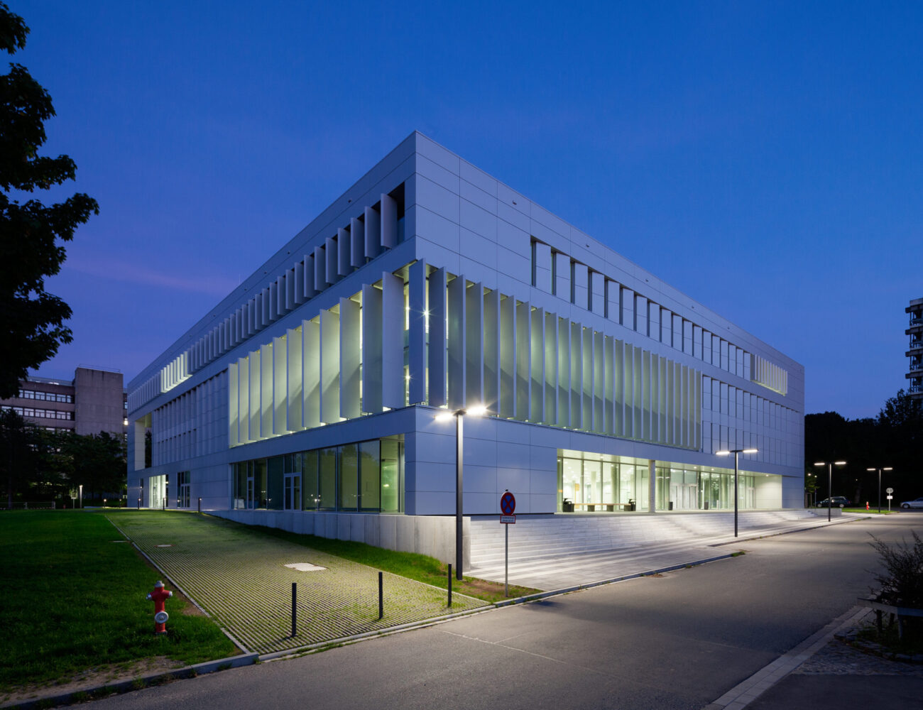 Der Haupteingang an der Westfassade und die Nordfassade mit Abendbeleuchtung des  Hörsaal- und Medienzentrums auf dem Campus Lichtwiese der TU Darmstadt. Das Gebäude wurde nach den Plänen des Architekten und TU-Alumnus Ferdinand Heide aus Frankfurt gebaut und am 7. Mai 2013  eröffnet. Der Hörsaalbereich umfasst vier Hörsäle, 20 Lern- und Seminarräume sowie Multifunktions-, Schulungs- und Rechnerräume. Mobile Trennwände erlauben das Zusammenschalten der Hörsäle, so dass mit fast 900 Plätzen der größte Hörsaal der TU zur Verfügung steht. Des Weiteren ist im Gebäude eine Bibliothek untergebracht, die die vorher dezentral zugänglichen Bestände der Fachbibliotheken des Campus Lichtwiese zusammenführt und zwei Fachlesesäle mit  Freihandbereichen beherbergt.